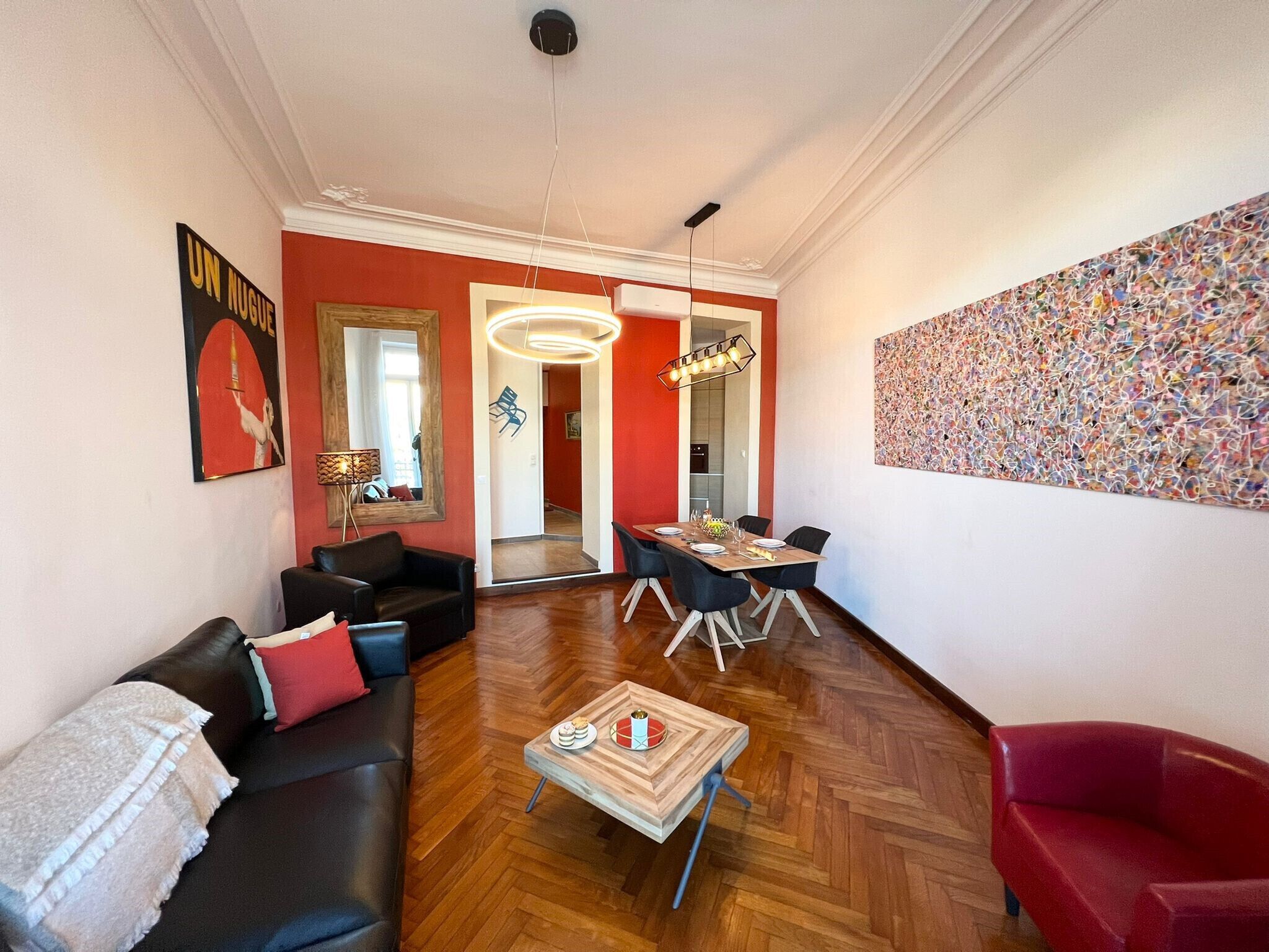 Una sala de estar moderna con sofá, mesa de centro y comedor con sillas.