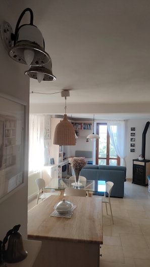 Ett modernt kök med ett matbord, stolar och en hängande lampa.