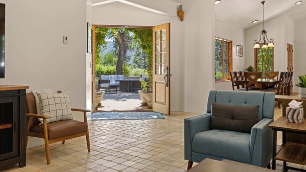 Amplia sala de estar con mesa y sillas de comedor, y vistas al exterior.