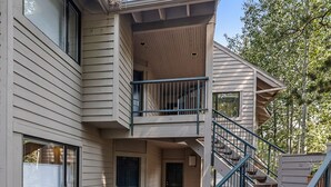 A two-story building with a wooden deck and a staircase leading to the upper level. - New Listing! Hotel style suite in Mt. Bachelor Village! (Bend)