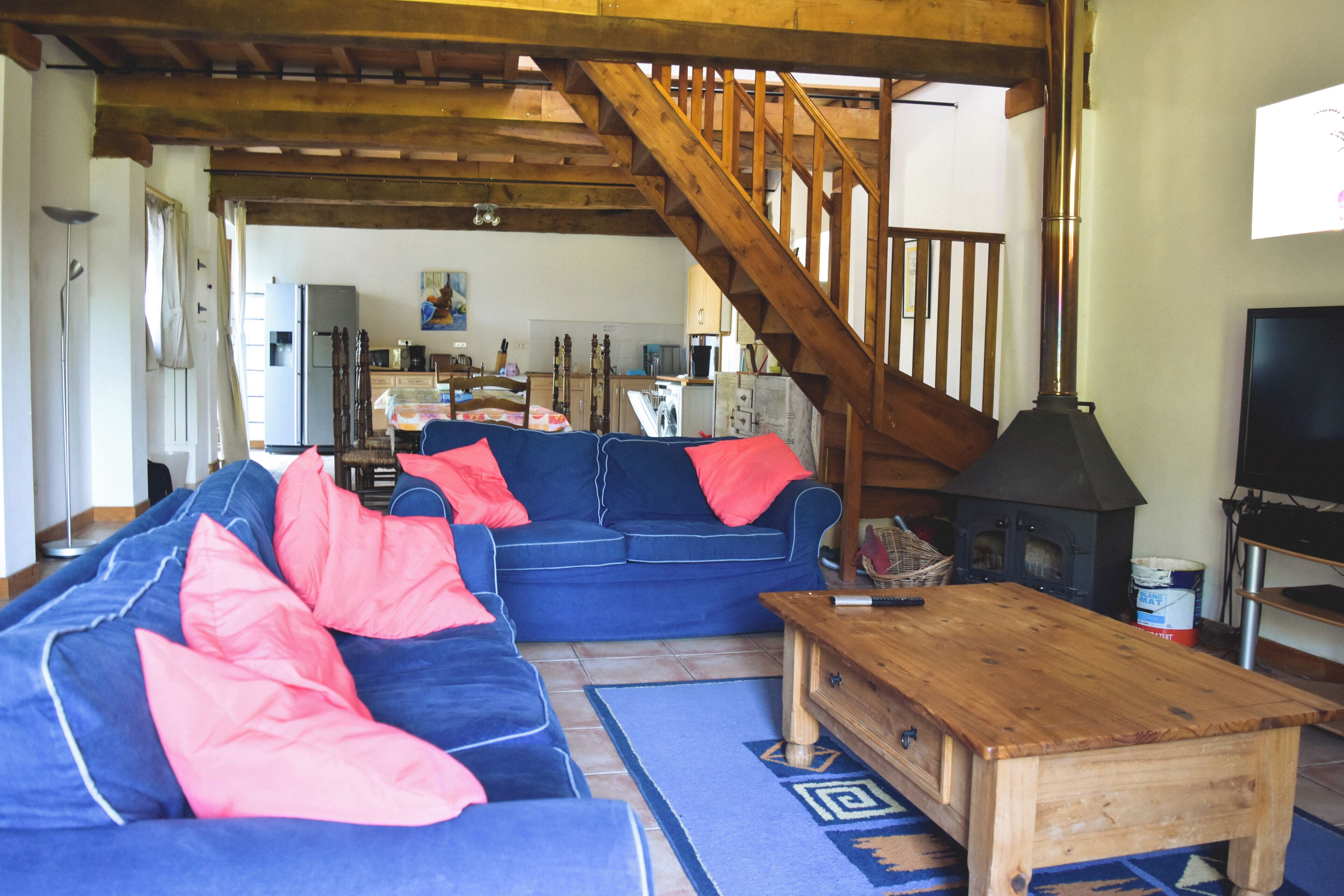 A living room with a blue sofa, wooden coffee table, and a staircase.