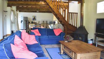 A living room with a blue sofa, wooden coffee table, and a staircase.