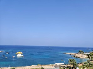 A coastal view with boats, a rocky shoreline, and a clear sky. - Charming 1-bed Apartment in Protaras, Cyprus (Paralimni)