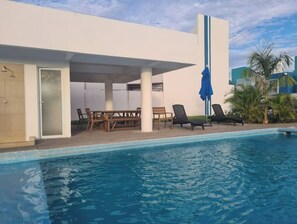 A swimming pool area with a covered seating area, a table, and lounge chairs. - House near Pto and Nvo Vallarta Bucerias Sayulita (Bahia de Banderas)