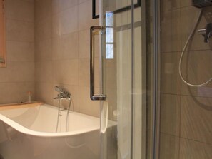 A modern bathroom with a glass-enclosed shower and a freestanding bathtub. - Muscardin 5/6 by Interhome (Villars)