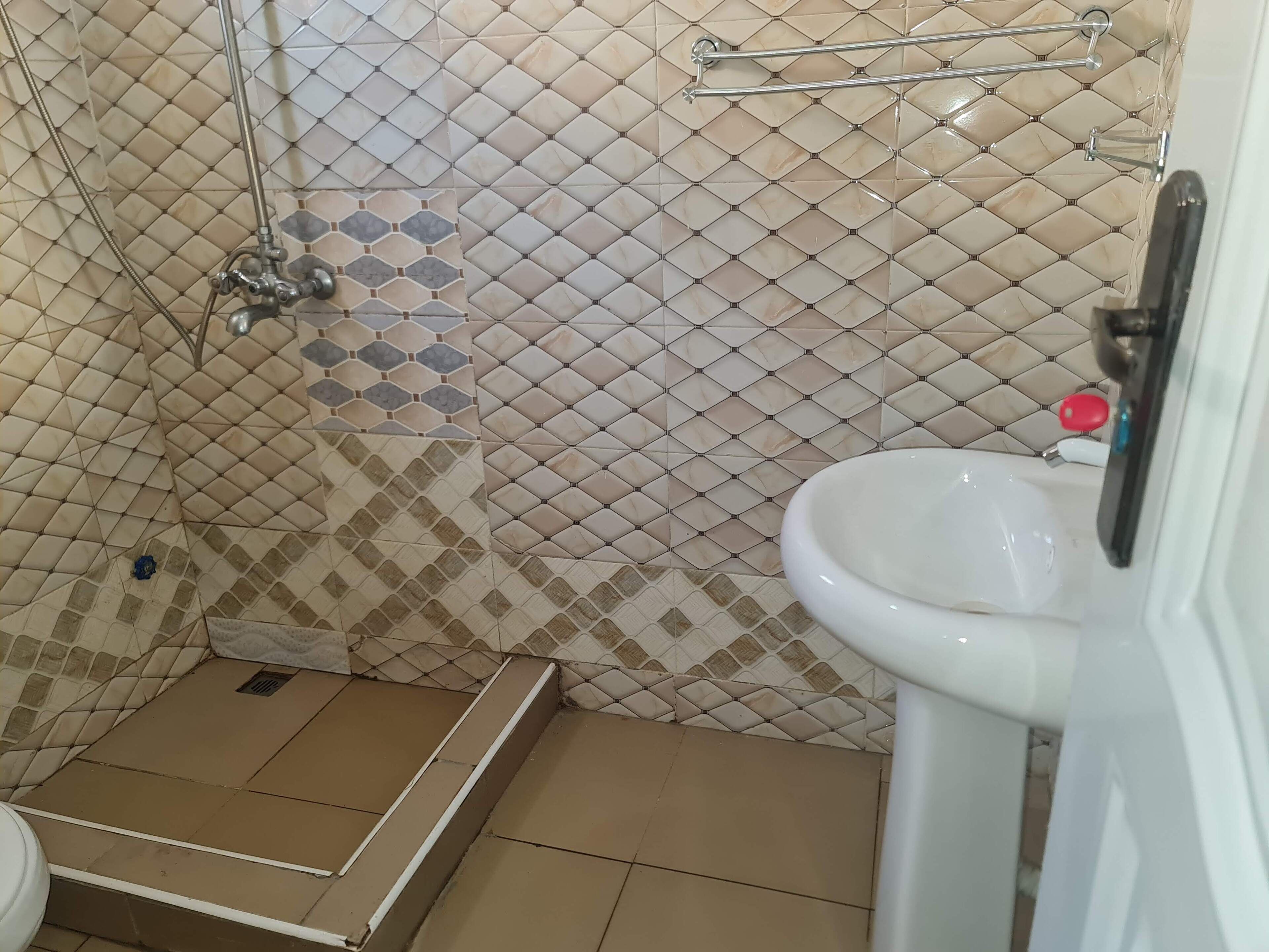 A bathroom with a shower, a toilet, and a sink.