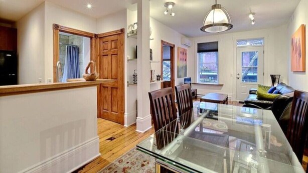 A modern kitchen with wooden cabinets, a glass dining table, and a view to the outside. - Luxury Quiet Old Montreal Home (Montréal)