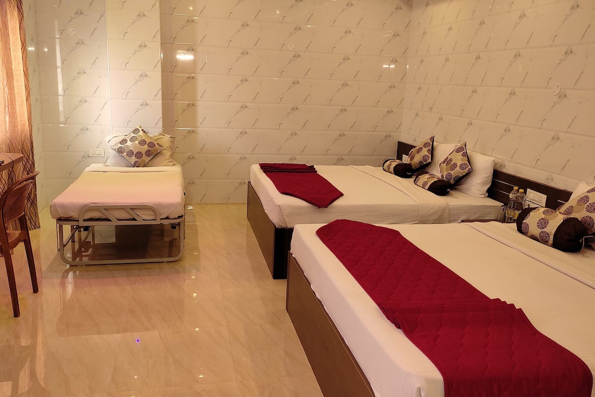 Ein Hotelzimmer mit zwei Betten, einem kleinen Tisch und einem Stuhl.