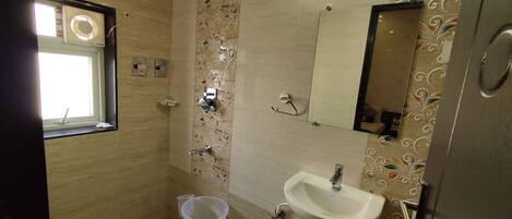 A bathroom with a window, a sink, a mirror, and a toilet.