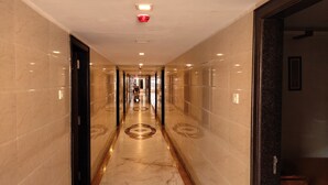 A corridor with marble walls and a patterned floor, leading to a door at the end. - Sri Maharaja Residency (Tiruchirappalli)