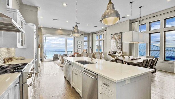 A spacious kitchen with a large island, modern appliances, and a view to the outside.