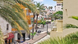 Vista de una calle con edificios, palmeras y un letrero que dice 'Diego'.