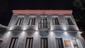 Un edificio con balcón, varias ventanas y una placa en la pared.