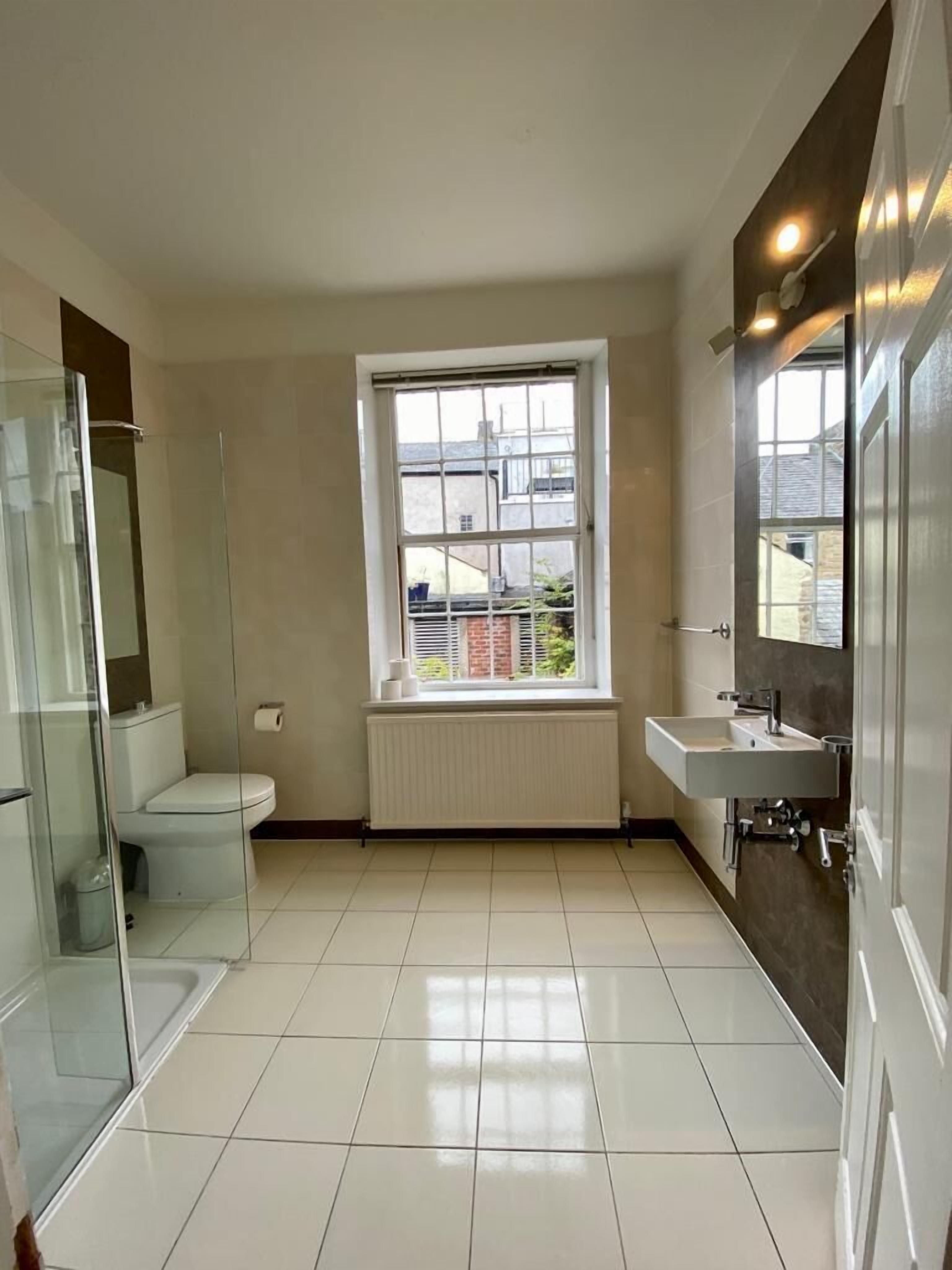 Une salle de bain moderne équipée de toilettes, d’une douche et d’un lavabo.