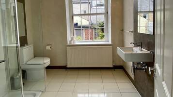 A modern bathroom with a toilet, shower, and sink.