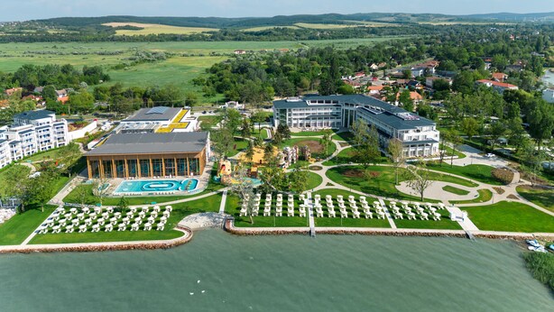 A resort with a swimming pool, a tennis court, and a landscaped garden. - Mövenpick Balaland Resort Lake Balaton (Szantod)