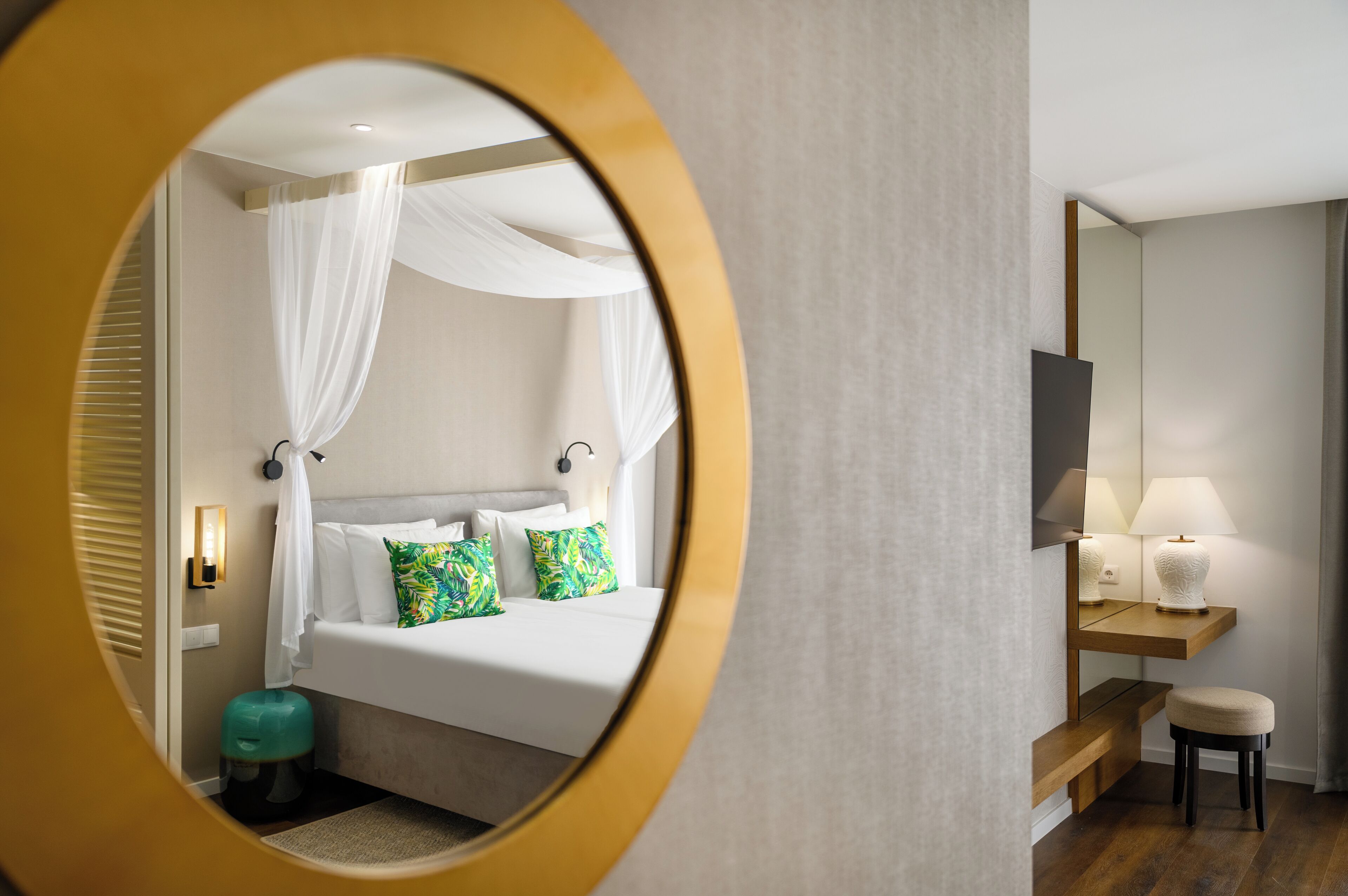 Une chambre à coucher moderne avec un lit, une table de chevet, une lampe et un miroir.