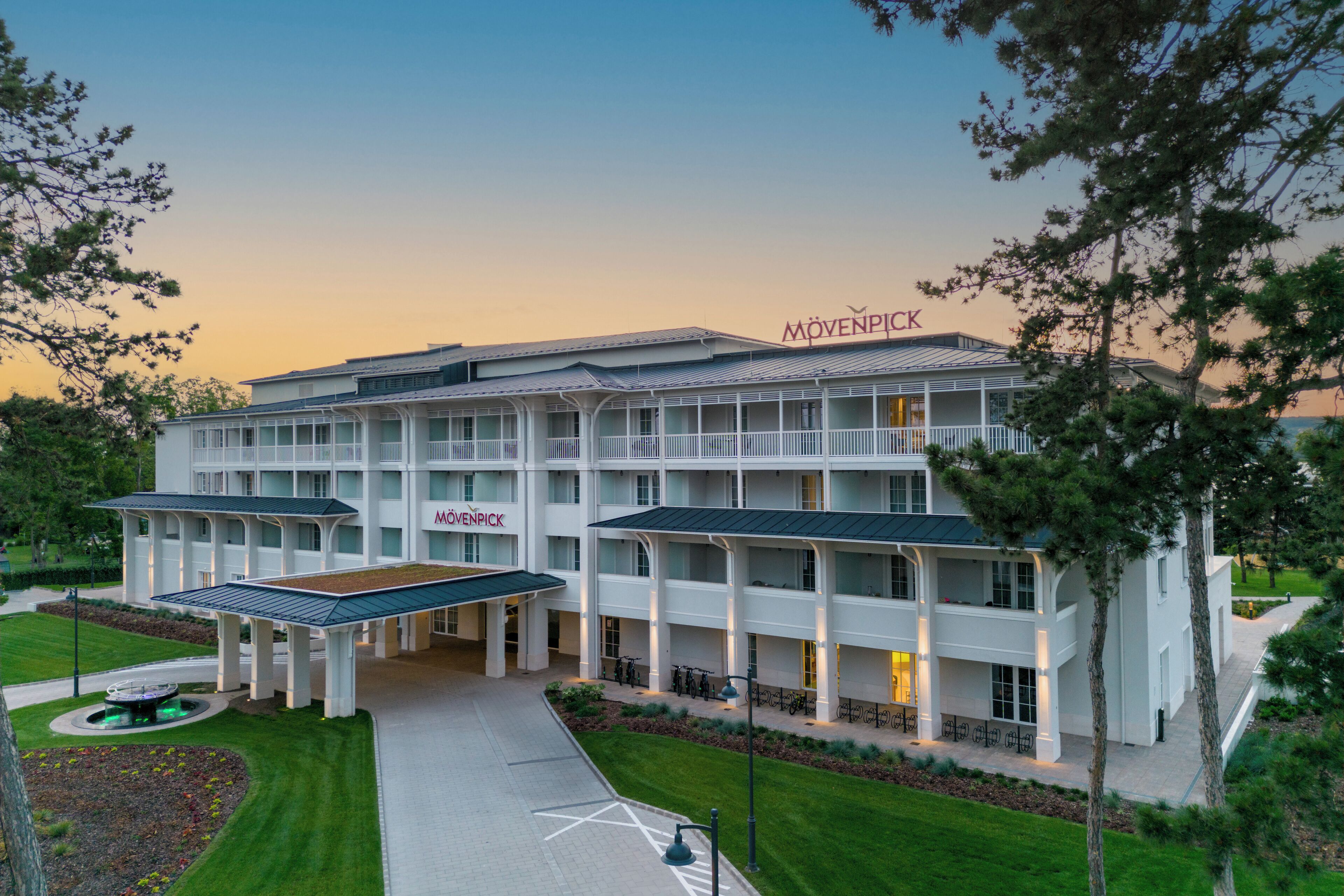 Un hôtel moderne doté d’une cour intérieure, de nombreux balcons et d’une enseigne « Mövenpick » bien visible.