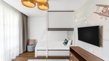 Un dormitorio moderno con una cama litera, un televisor de pantalla plana y un mural decorativo.