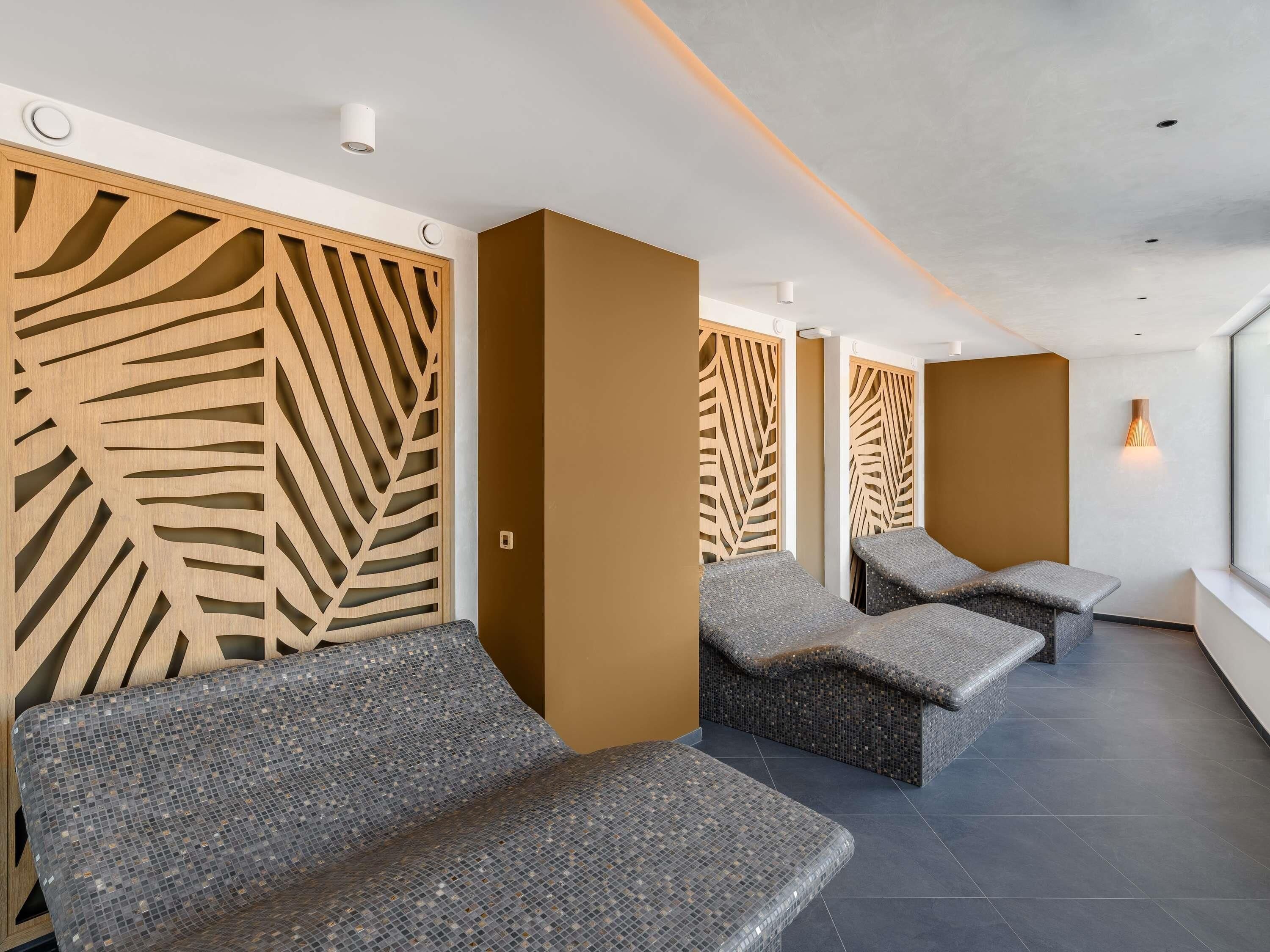 A spa area with seating, wooden panels, and a modern ceiling design.