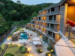 A hotel with a pool, outdoor seating, and a view of the surrounding forest. - Minaro Hotel Tokaj - MGallery Collection (Tokaj)