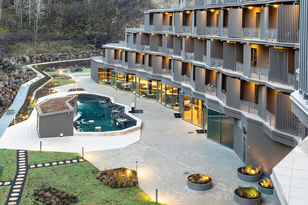 Un hôtel moderne doté de nombreux balcons, d’une piscine et de jardins aménagés.