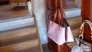 Un escalier en bois mène à une chambre à coucher qui contient un lit et un fauteuil en osier.