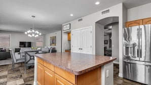 A modern kitchen with a granite countertop, stainless steel appliances, and wooden cabinetry. - Spacious 5 BR, 3.5 BA, 4000+sf, WiFi, Pool,Hot Tub (Gilbert)