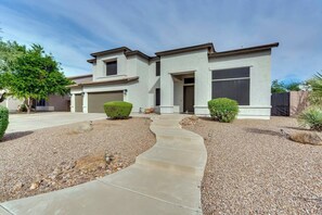 A two-story house with a driveway leading to the garage, surrounded by gravel and small plants. - Spacious 5 BR, 3.5 BA, 4000+sf, WiFi, Pool,Hot Tub (Gilbert)