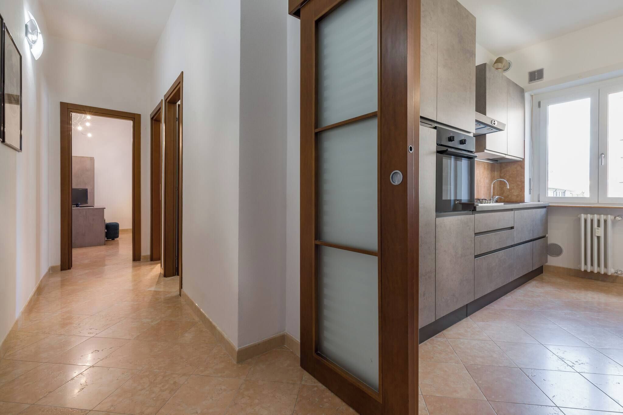 A modern kitchen with a built-in oven and a window.