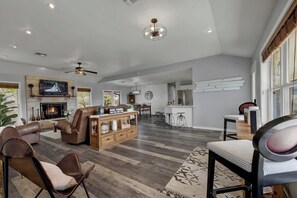A spacious living room with a fireplace, leather sofas, and a dining area. - Starlight Meadows Hot-tub 3mi to Downtown (Fredericksburg)