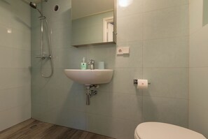 Ein Badezimmer mit Dusche, Waschbecken und Toilette.