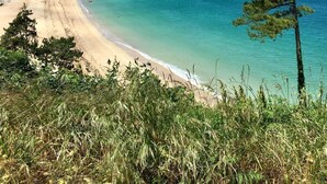 A coastal landscape with a sandy beach, clear turquoise waters, and a distant town. - La Grande Plage - Three Bedroom Apartment, Sleeps 5 (Saint-Cast-le-Guildo)