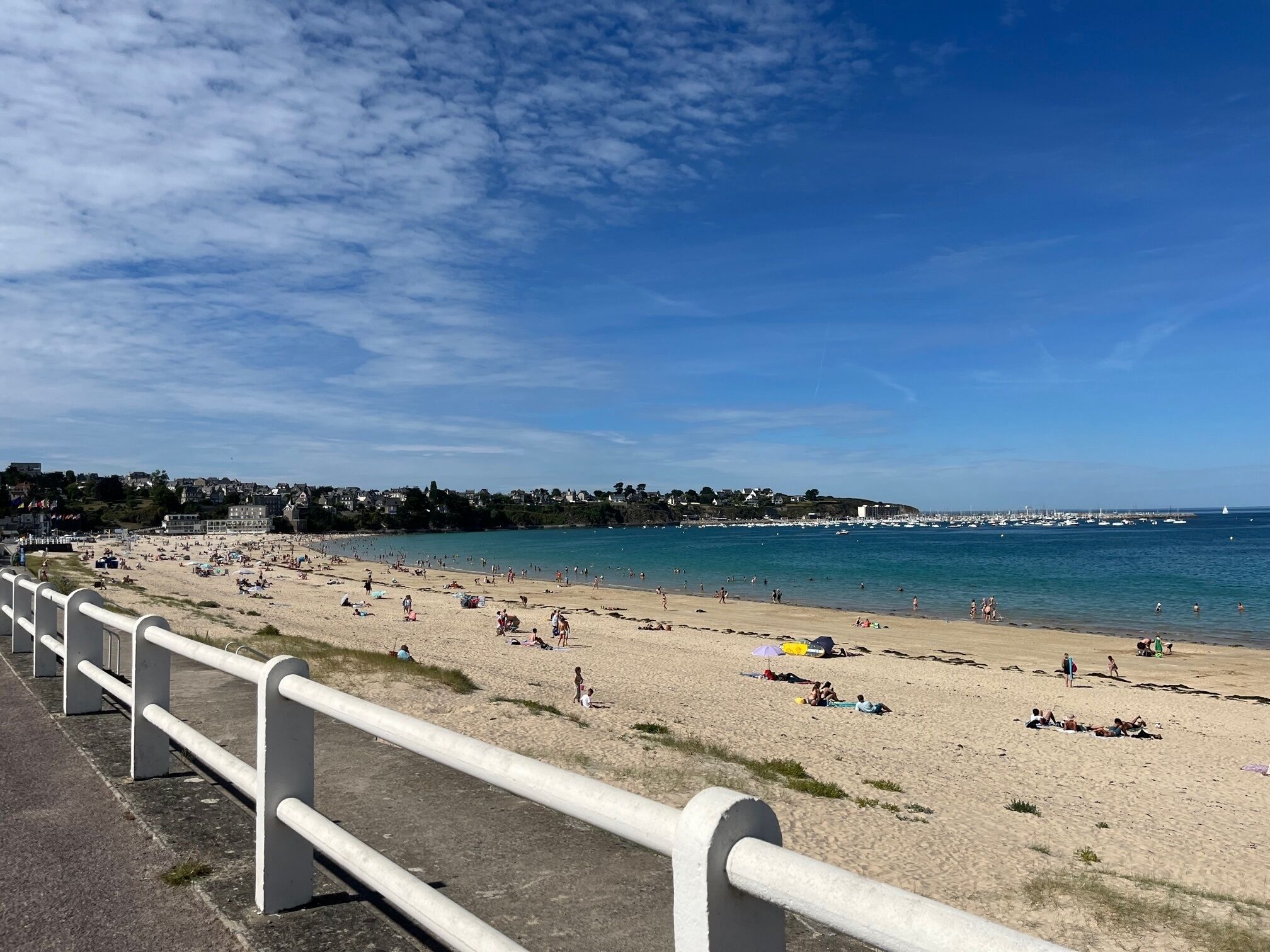 Ein Strand mit befestigtem Gehweg und Geländer.
