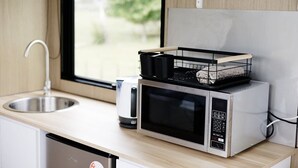 A kitchen with a microwave, a kettle, and a sink. - Rural Delight by Tiny Away (Ohaupo)