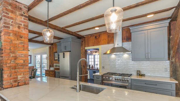 A kitchen with a marble countertop, stainless steel appliances, and wooden beams. - A Quintessential New England Historical Guesthouse (Groton)