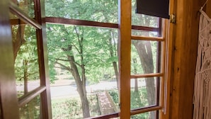 A wooden interior with a large sliding glass door leading to an outdoor area with potted plants.