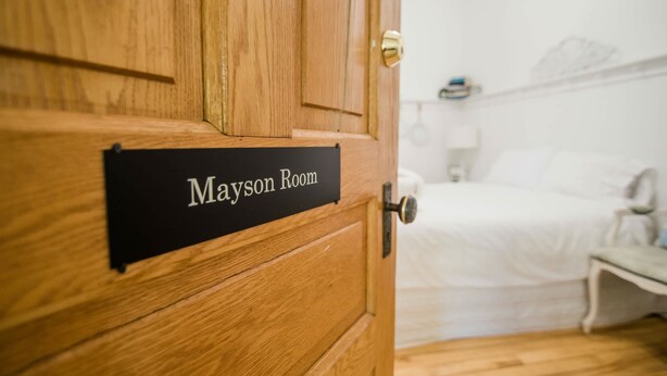 Une porte en bois sur laquelle est apposée une plaque indiquant « Mayson Room ».