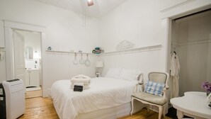 Une chambre d’hôtel avec un lit, une chaise, une table et un radiateur.