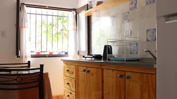 Hervidor eléctrico, tostadora, utensilios de cocina y mesa de comedor