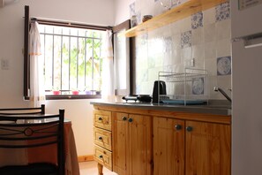 Tetera/pava eléctrica, tostadora, utensilios de cocina, mesa de comedor