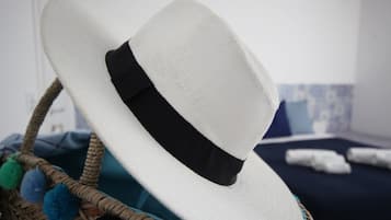 Un sombrero blanco con cinta negra sobre una cesta trenzada.