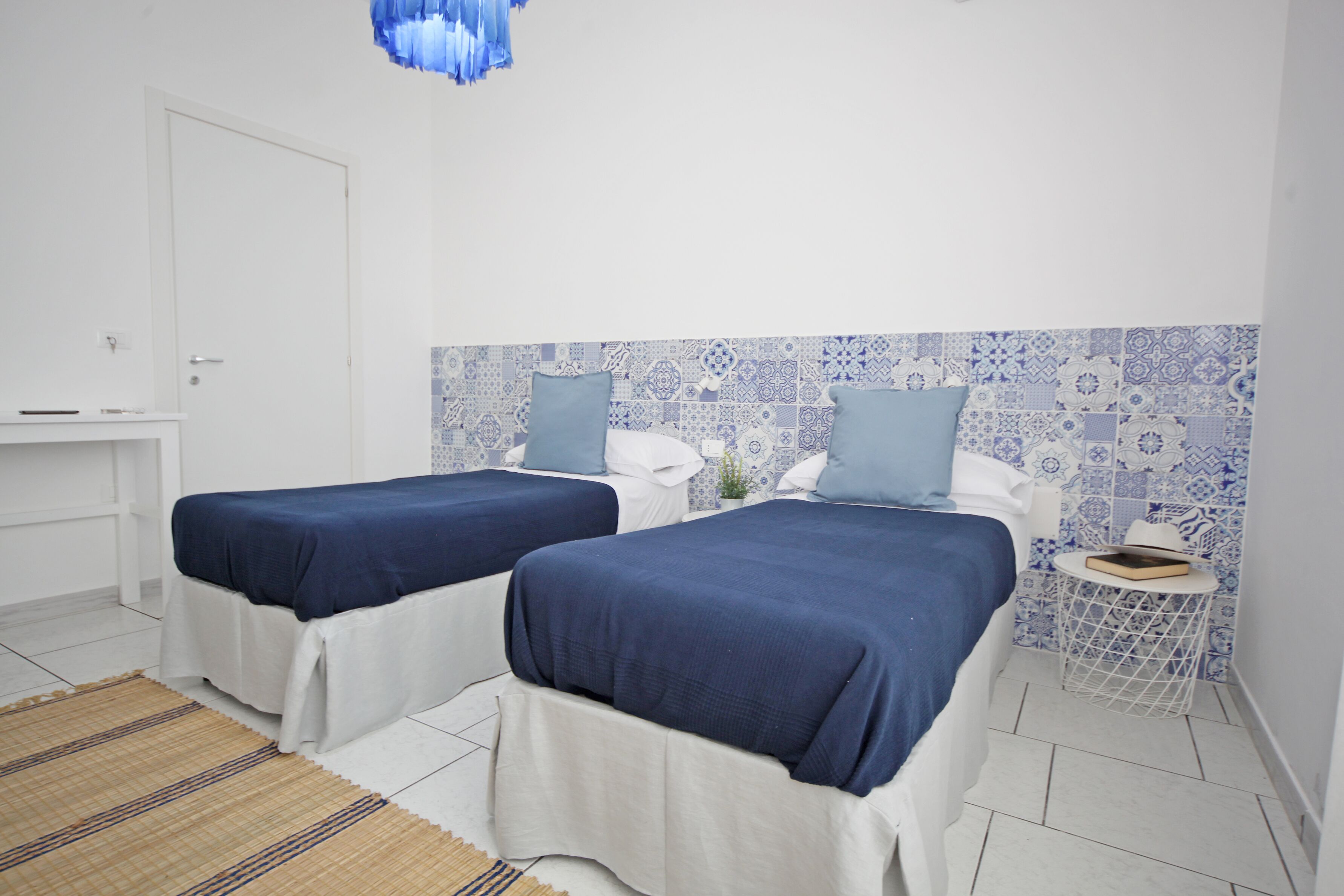 Habitación de hotel con dos camas, una mesita y un adorno en la pared.