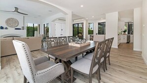 Un comedor espacioso con una mesa y sillas de madera, un sofá y un ventilador de techo.