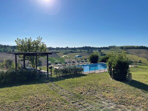 A pool area with a pergola, sun loungers, and a view of rolling hills. - Stunning views, close to sandy beaches and gorgeous mountains (Montegiorgio)