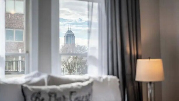 Una habitación de hotel con vistas a un paisaje urbano a través de una ventana.