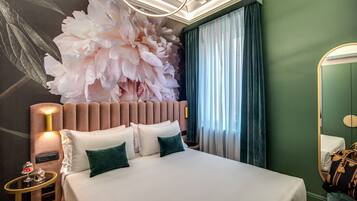 Quarto de hotel moderno com uma cama grande, um painel decorativo na parede, um espelho redondo e uma mesa de cabeceira com abajur.