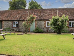 A rustic building with a stone facade, a green door, and a brick roof.