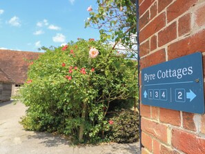 A sign for 'Byre Cottages' with directional arrows pointing to numbers 1, 3, 4, and 2.