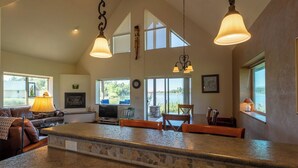 A spacious kitchen with a large island, high ceilings, and ample natural light from large windows.